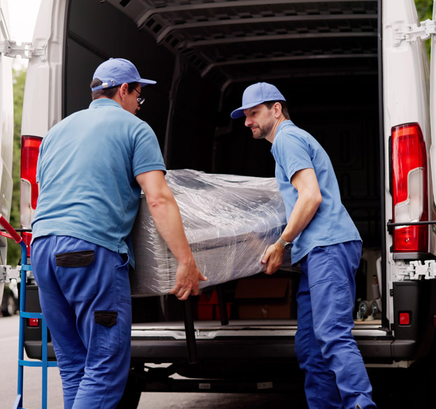 Professional movers loading wrapped furniture into a moving van.