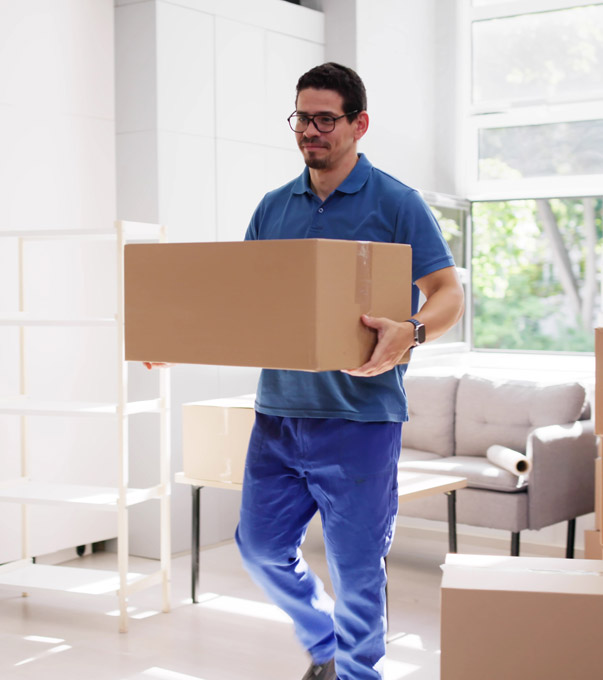 Professional mover carrying a moving box inside a home.