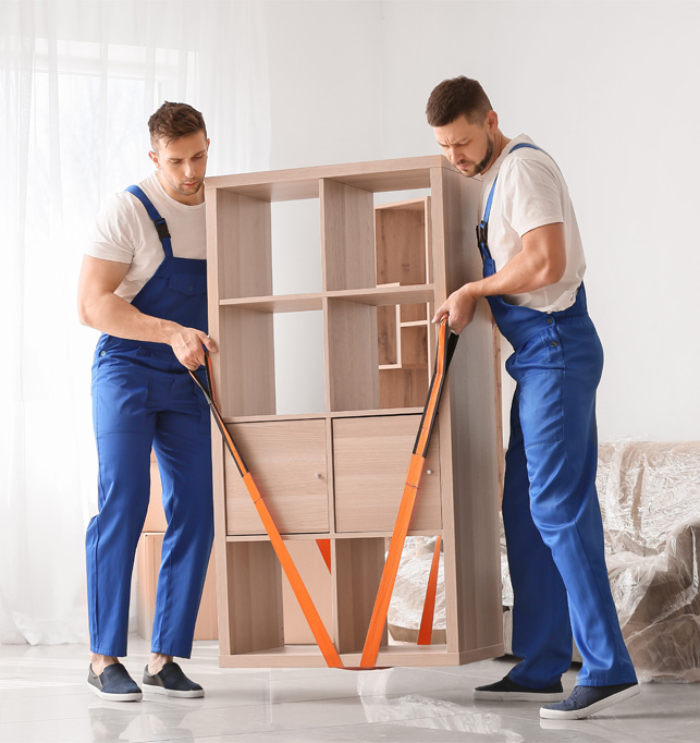 Professional movers carrying furniture inside a home.