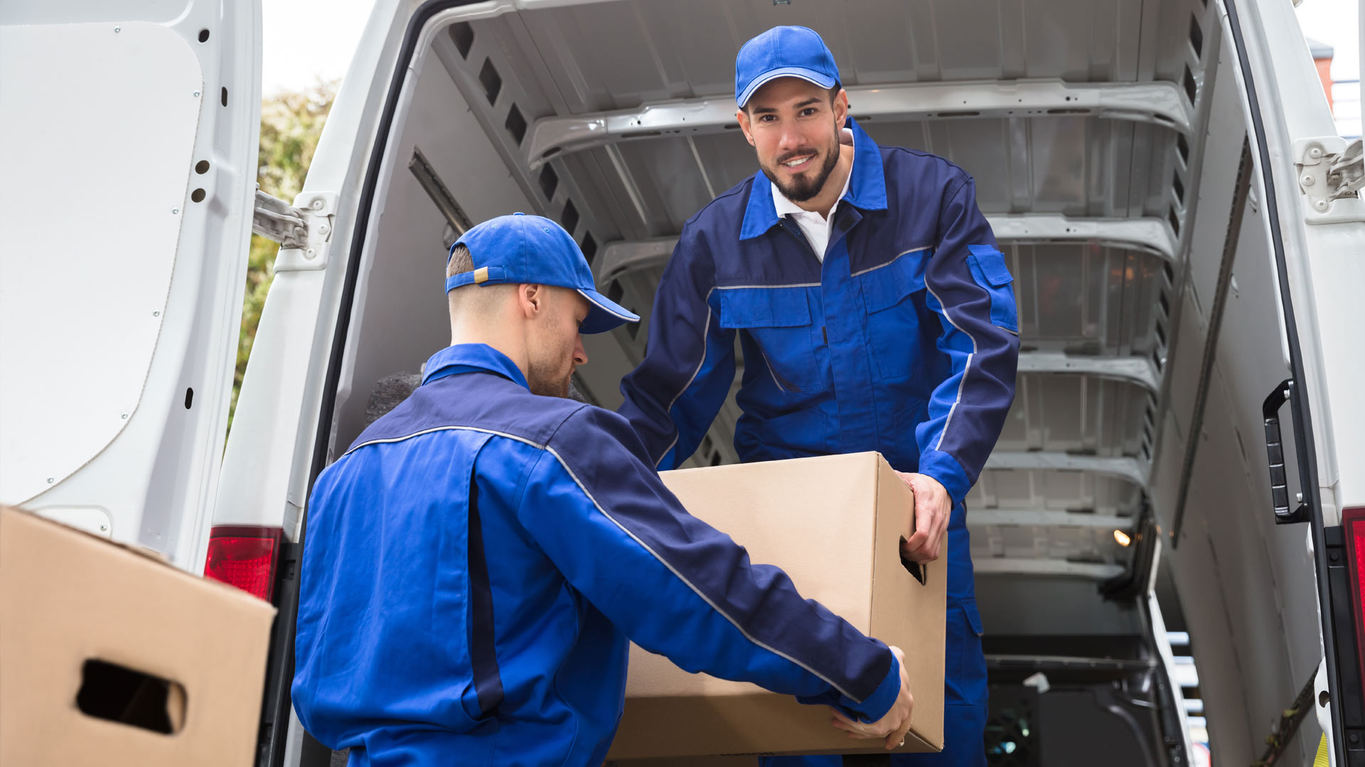 Professional movers loading moving boxes into a moving truck.