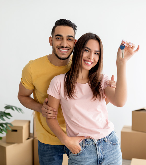 Happy couple celebrating their new home with house keys.