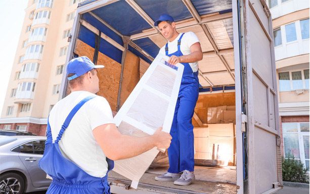 Professional movers unloading moving boxes from a moving truck.