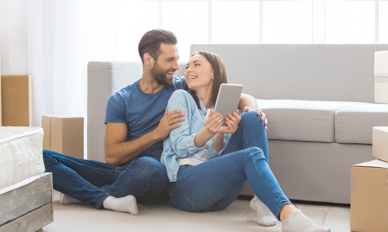 Happy couple relaxing in their new home after moving.