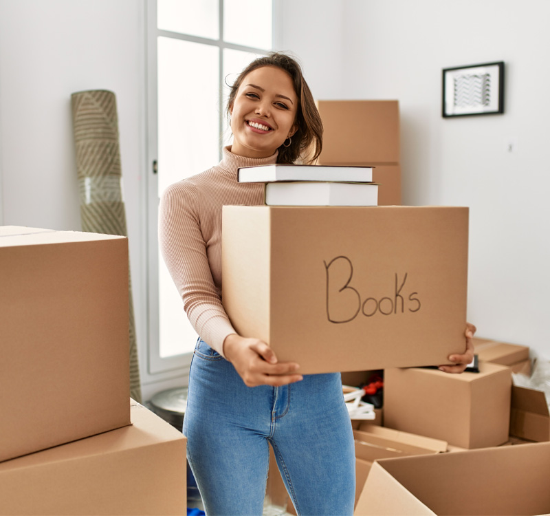 Woman holding a box labeled "Books."