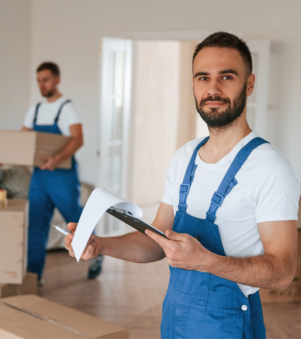 Professional movers reviewing paperwork with moving boxes.
