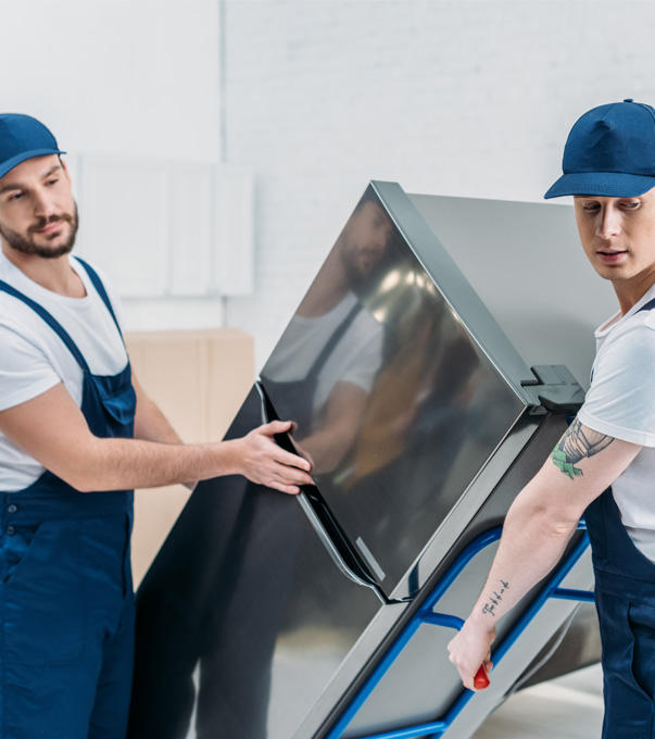 Professional movers moving a refrigerator together.