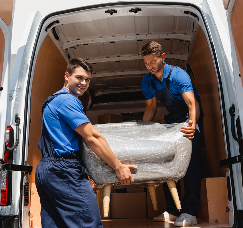 Professional movers loading wrapped furniture into a moving truck.