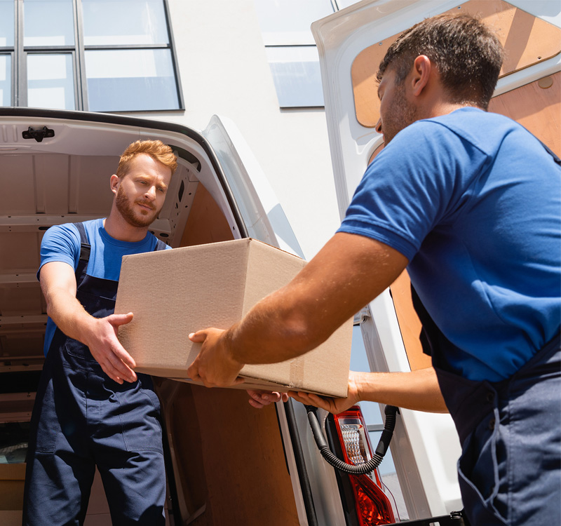 Professional movers loading a moving box into a moving truck.