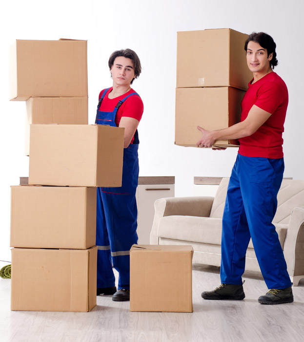 Professional movers carrying moving boxes inside a room.