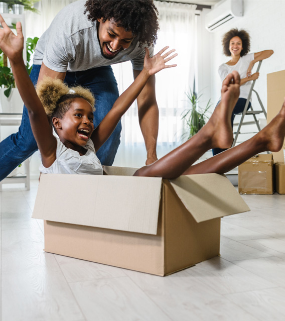 Family playing inside a cardboard box after moving.