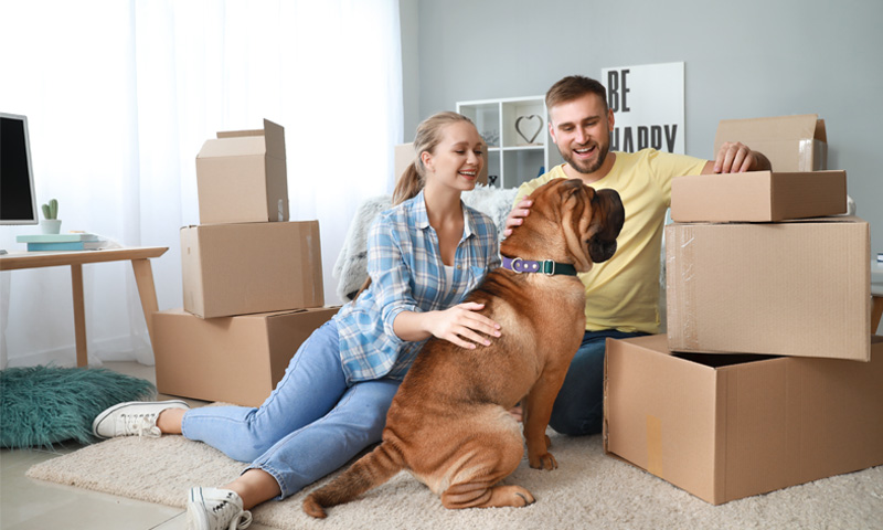 Happy family with their dog enjoying their new home after moving.