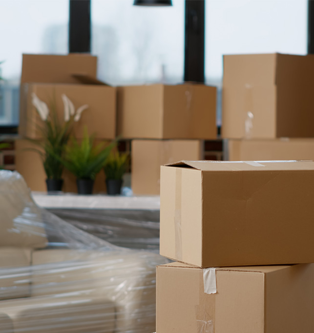 Cluttered room filled with moving boxes and furniture.