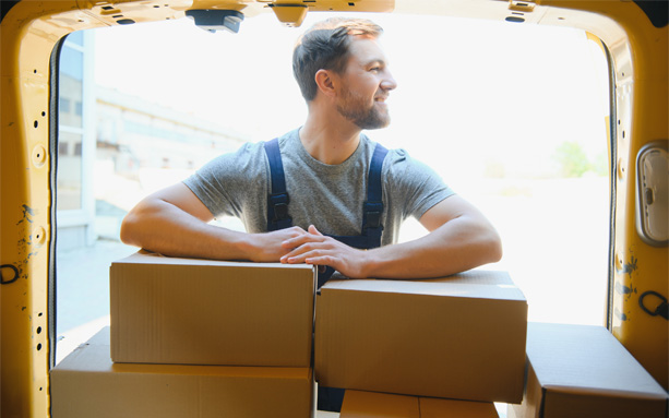 Professional mover sitting inside a moving truck with boxes.
