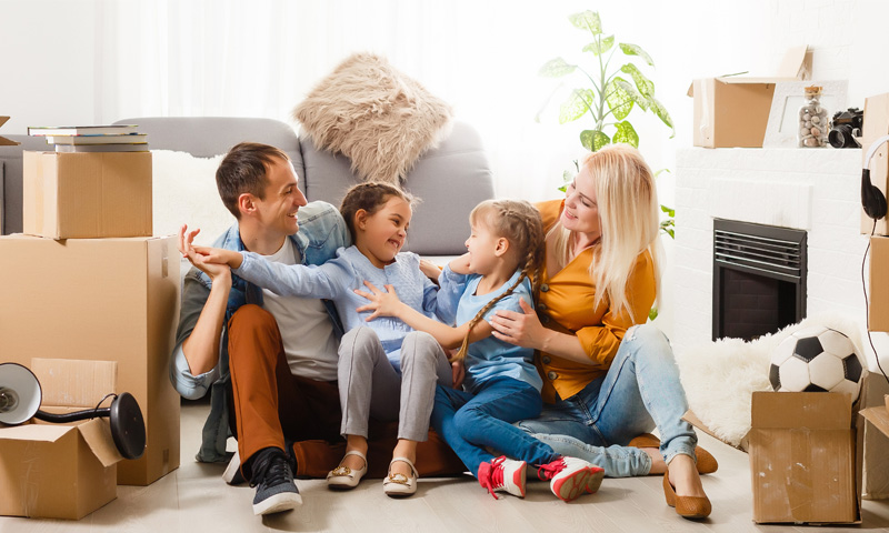 Happy family sitting among moving boxes after a move.