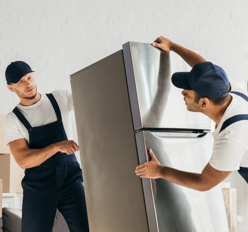 Professional movers moving a refrigerator together.