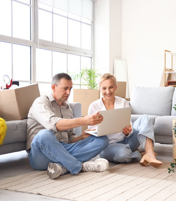 Couple using a laptop in their new home.
