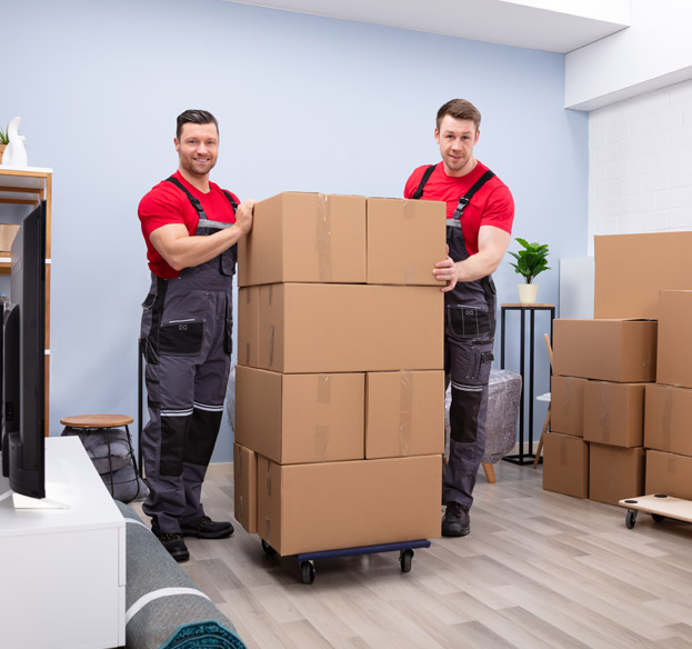 Professional movers transporting moving boxes inside a home.