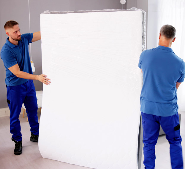 Professional movers carrying a mattress together.
