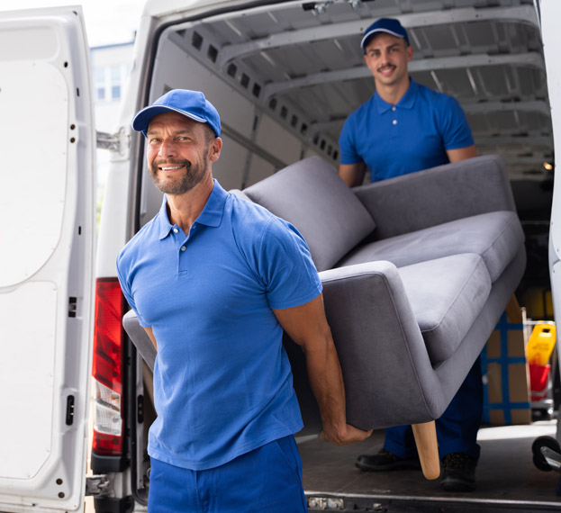 Professional movers unloading a sofa from a moving truck.