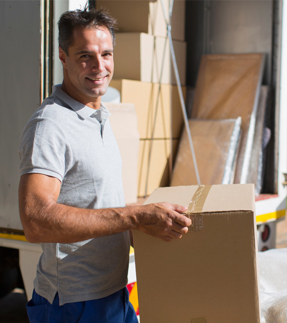 Professional mover carrying a moving box in front of a moving truck.