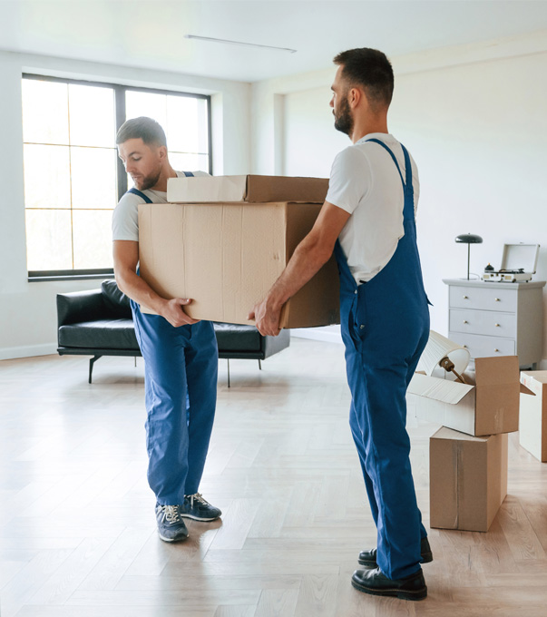 Professional movers transporting moving boxes through a living room.