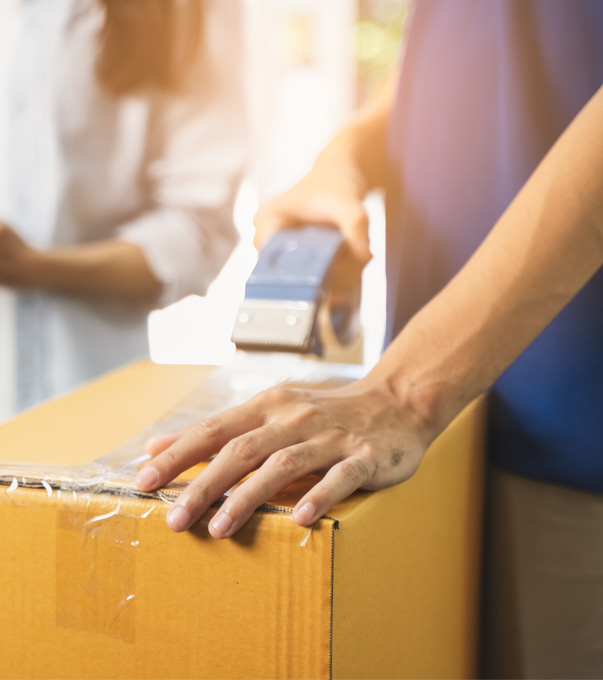 Happy couple standing with a moving box.