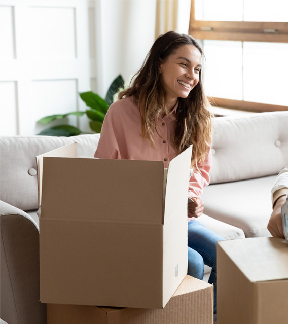 Happy couple sitting among moving boxes after a move.