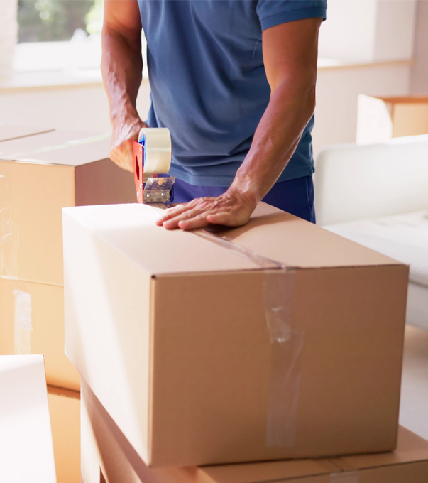 Professional mover carrying moving boxes inside a room.