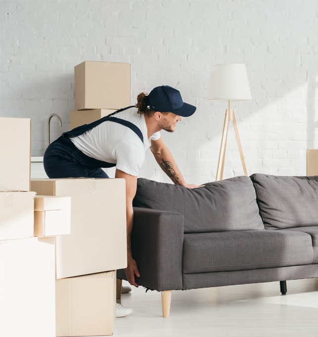 Professional mover carrying moving boxes into a room.