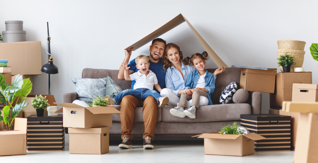 Happy family sitting among moving boxes after a move.